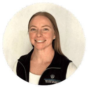Smiling woman with straight light brown hair, wearing a black vest with a Northwestern Health Sciences University logo, posed in front of a plain light background.
