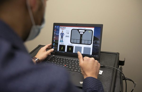 Dr. Reis using balance-testing technology in the Sweere Clinic
